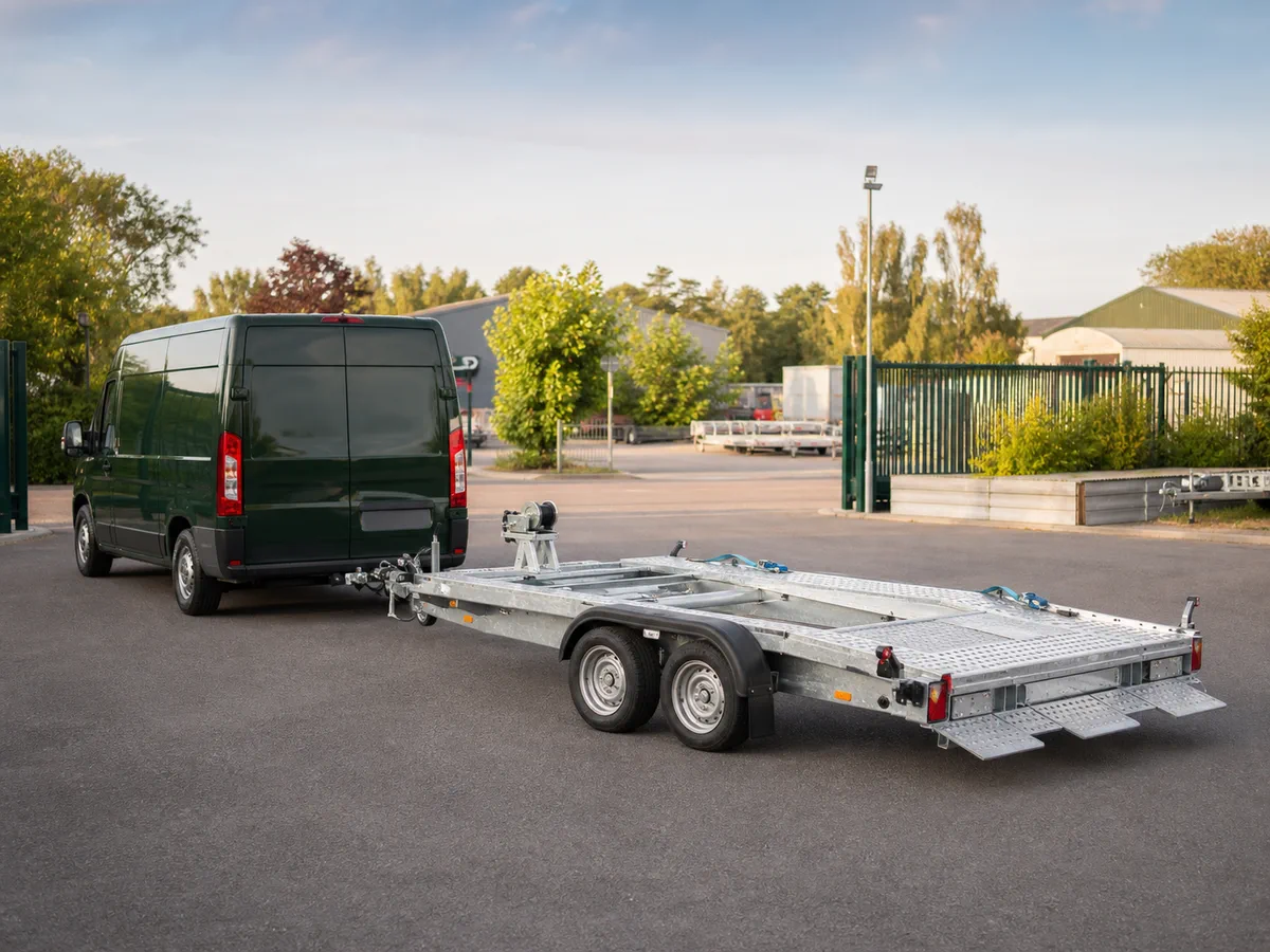 Een autotransporter gekoppeld aan een bestelwagen, klaar om opgehaald te worden