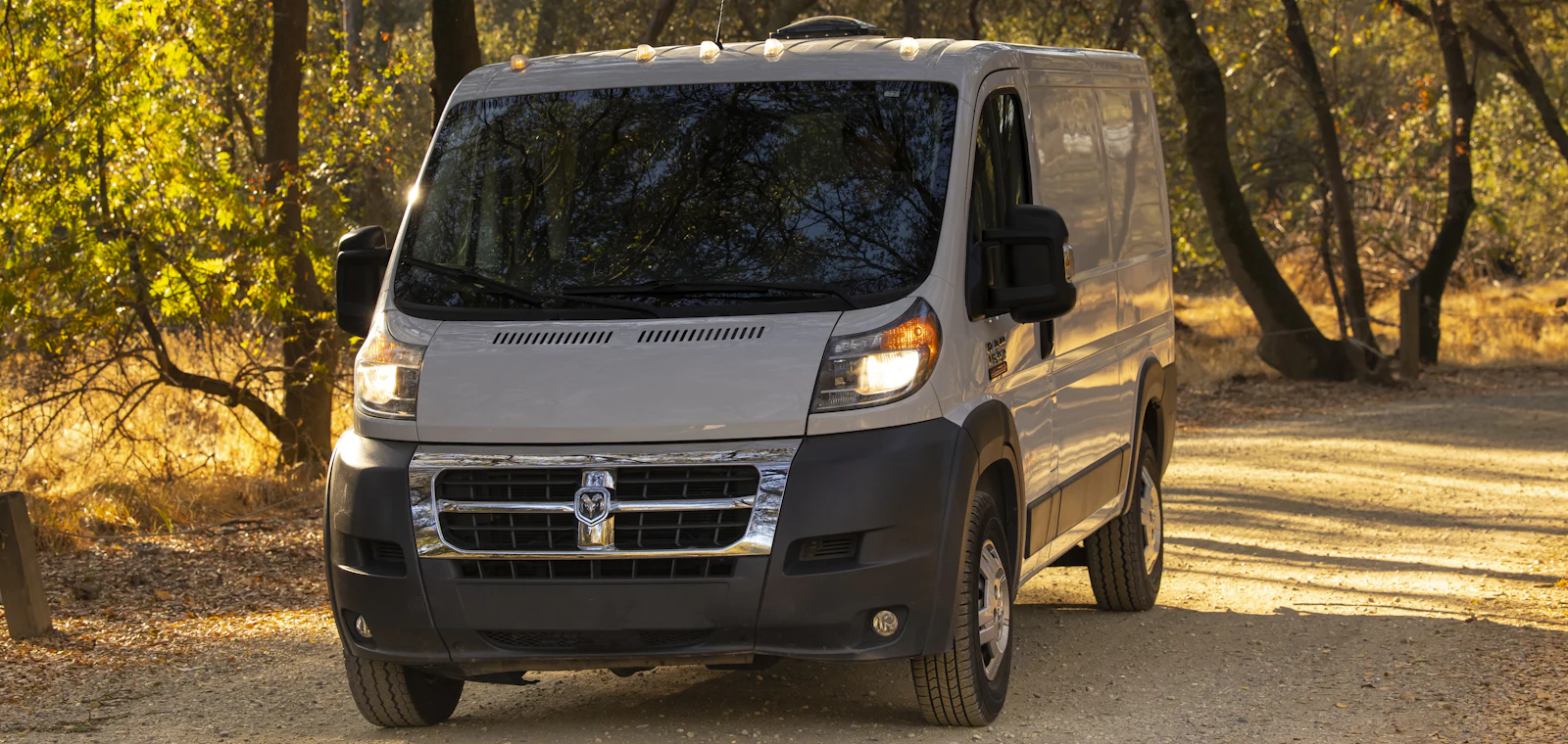 A white cargo van used for van rental, parked on a road
