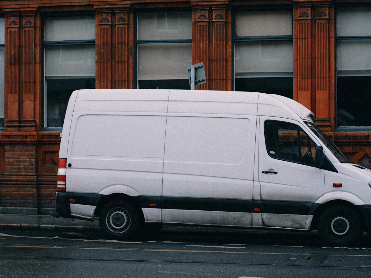 A white cargo van parked on a city street